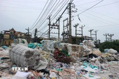 Trạm biến áp điện ở làng nghề Minh Khai bị rác thải nhựa quây kín, tiềm ẩn nguy cơ cháy nổ. (Ảnh: Mạnh Khánh/TTXVN)