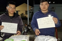 Hai đối tượng có hành vi phát tờ rơi cho vay trả góp bị lực lượng Công an xã Vĩnh Hòa bắt quả tang. (Ảnh: TTXVN phát)