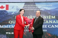 Ông Hồ Xuân Lâm, Phó Chủ tịch kiêm Tổng thư ký Liên hiệp các tổ chức hữu nghị Thành phố Hồ Chí Minh, tặng hoa chúc mừng bà Annie Dube, Tổng Lãnh sự Canada tại Thành phố Hồ Chí Minh. (Ảnh: Xuân Khu/TTXVN)