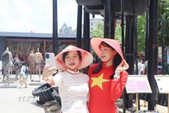 Người dân ghi lại những khoảnh khắc trong dịp lễ kỷ niệm ngày thống nhất đất nước. (Ảnh: Thu Hương/TTXVN)