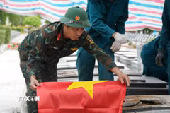 Lực lượng chức năng thực hiện di quách để làm nhiệm vụ lấy mẫu xét nghiệm. (Ảnh: Lê Xuân/TTXVN) 