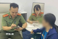 Cán bộ Phòng An ninh mạng và phòng chống tội phạm sử dụng công nghệ cao giải thích cho bà B về thủ đoạn của các đối tượng lừa đảo. (Ảnh: TTXVN phát)