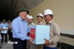Phó Thủ tướng Thường trực Nguyễn Hòa Bình tặng quà cho công nhân đang thi công tại hầm Sơn Triệu (Thị xã An Nhơn, Bình Định). (Ảnh: Sỹ Thắng/TTXVN)