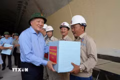 Phó Thủ tướng Thường trực Nguyễn Hòa Bình tặng quà cho công nhân đang thi công tại hầm Sơn Triệu (Thị xã An Nhơn, Bình Định). (Ảnh: Sỹ Thắng/TTXVN)