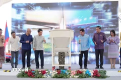 Phó Thủ tướng hai nước Lào-Thái Lan và đại diện các bộ, ngành hai nước thực hiện nghi thức đổ bê tông hợp long cầu. (Ảnh: Xuân Tú/TTXVN)