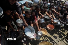 Người dân Palestine chờ nhận thức ăn cứu trợ tại thành phố Gaza, ngày 24/7/2025. (Ảnh: THX/TTXVN)