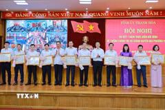 Phó Bí thư Thường trực Tỉnh ủy Nguyễn Hồng Phong và Phó Bí thư Tỉnh ủy Trịnh Tuấn Sinh trao Bằng khen của Chủ tịch Ủy ban Nhân dân tỉnh và tặng hoa cho các cá nhân có thành tích xuất sắc trong thực hiện mô hình hệ thống chính trị và chính quyền địa phương 2 cấp. (Ảnh TTXVN phát)