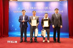 Giáo sư, Tiến sỹ Chu Hoàng Hà, Phó Chủ tịch Viện Hàn lâm Khoa học và Công nghệ Việt Nam trao Thông báo kết quả giám định ADN hài cốt liệt sỹ cho thân nhân liệt sỹ. (Ảnh: Quyết Chiến/TTXVN)