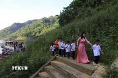 Cô giáo đón các em học sinh đến trường dự khai giảng năm học mới. (Ảnh: Trọng Đạt/TTXVN)