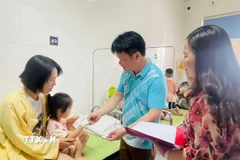 Lãnh đạo thành phố Cao Bằng thăm hỏi các em nghi bị ngộ độc thực phẩm được điều trị tại Bệnh viện đa khoa tỉnh. (Ảnh: TTXVN phát)