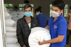 Người dân nhận gạo hỗ trợ của Chính phủ. (Ảnh: Hưng Thịnh/TTXVN)