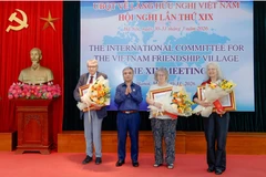 Thừa ủy quyền của Chủ tịch nước, Thượng tướng Phạm Hồng Hương trao tặng Huân chương Hữu nghị cho các thành viên của Ủy ban quốc tế về Làng Hữu nghị Việt Nam. (Nguồn: Đại đoàn kết)
