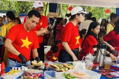 Cán bộ Đại sứ quán Việt Nam chuẩn bị món bánh mỳ phục vụ khách tham quan. (Ảnh: ĐSQ cung cấp)