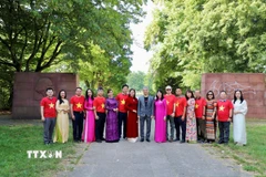Đại sứ Tiến cử Nguyễn Đắc Thành cùng đại biểu và đảng viên chụp ảnh lưu niệm trước tượng đài Karl Marx tại Berlin. (Ảnh: Phương Hoa/TTXVN)