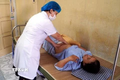 Bác sỹ khoa Phụ sản (bệnh viện Đại học Y Thái Bình) thăm khám cho bệnh nhân M.T.T (50 tuổi, trú tại tỉnh Ninh Bình). (Ảnh: Nguyễn Công Hải/TTXVN)