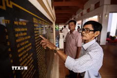 Trở lại chiến khu xưa, những đồng đội cũ lặng lẽ dừng chân trước bia tưởng niệm, tìm lại tên những người đồng chí đã anh dũng ngã xuống. (Ảnh: Giang Phương/TTXVN)