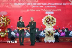 Thượng tá Trần Thị Anh Thư, Giám đốc Bảo tàng Quân khu 5 (trái) tiếp nhận các hiện vật được trao tặng tại buổi tổng kết. (Ảnh: Trần Lê Lâm/TTXVN)