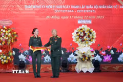 Thượng tá Trần Thị Anh Thư, Giám đốc Bảo tàng Quân khu 5 (trái) tiếp nhận các hiện vật được trao tặng tại buổi tổng kết. (Ảnh: Trần Lê Lâm/TTXVN)
