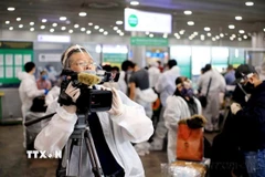 Trưởng Cơ quan Thường trú TTXVN tại Liên bang Nga, Bùi Duy Trinh đưa tin về chuyến bay đầu tiên đưa hơn 300 công dân Việt Nam từ Liên bang Nga về nước trong bối cảnh đại dịch COVID-19, tại sân bay Sheremetyevo (5/2020). (Ảnh: TTXVN) 