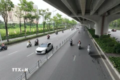Xây dựng và triển khai phương án phân làn bằng dải phân cách cứng trên đường Phạm Văn Đồng. (Ảnh: Nguyễn Thắng/TTXVN)