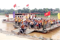 Người dân di chuyển qua sông tại Phú Thọ. (Ảnh: Tạ Toàn/TTXVN)
