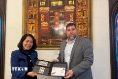 Nghị sỹ Victor Aldaya trao Đại sứ Ngô Minh Nguyệt bộ tem do Bưu chính Uruguay tháng 12/2013, nhân kỷ niệm 20 năm quan hệ ngoại giao Việt Nam-Uruguay, với chân dung của Đại tướng Võ Nguyên Giáp. (Ảnh: Diệu Hương/TTXVN) 