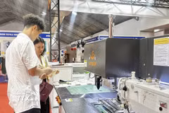 Nhà cung cấp giới thiệu máy móc, thiết bị hiện đại đến khách tham quan triển lãm. (Ảnh: Mỹ Phương/TTXVN)