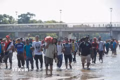Người di cư vượt sông Suchiate từ Guatemala để tới Mexico, trong hành trình đến Mỹ. (Ảnh: THX/TTXVN)