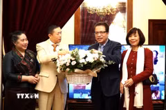 Đại sứ Đặng Minh Khôi và phu nhân Lê Linh Lan (ngoài cùng bên phải) chúc mừng Đại sứ Siphandon Oybuabuddi cùng phu nhân Ammala Vilavongsa. (Ảnh: Tâm Hằng/TTXVN)