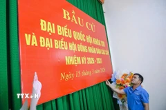 Thực hiện công tác trang trí tại khu vực bỏ phiếu Nhà văn hóa thôn Minh Hùng, xã Vạn Lộc. (Ảnh: Hoa Mai/TTXVN)