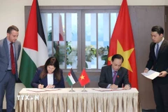 Bộ trưởng Bộ Ngoại giao Lê Hoài Trung và Bộ trưởng Ngoại giao và Kiều dân Palestine Varsen Aghabekian Shahin ký Hiệp định miễn thị thực cho người mang hộ chiếu ngoại giao. (Ảnh: An Đăng/TTXVN) 