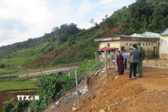 Phó Chủ tịch Thường trực Ủy ban Nhân dân tỉnh Quảng Ngãi Y Ngọc kiểm tra điểm sạt lở tại Trường Tiểu học và Trung học cơ sở Đăk Man, xã Đăk Plô. (Ảnh: Dư Toán/TTXVN)