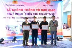 Chủ tịch Ủy ban Nhân dân xã A Vương Briu Quân tặng Giấy khen cho lực lượng tham gia “Chiến dịch Quang Trung” xây, sửa nhà ở cho đồng bào bị thiệt hại do thiên tai vào cuối tháng 10 và đầu tháng 11/2025. (Ảnh: TTXVN phát)