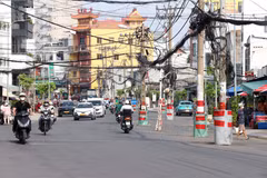 Nhiều trụ điện trên tuyến vẫn chưa được di dời, khiến dự án mở rộng đường Chu Văn An chưa thể hoàn thành, đồng thời ảnh hưởng đến an toàn giao thông và mỹ quan đô thị. (Ảnh: Tiến Lực/TTXVN)