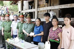 Thiếu tướng Đặng Trọng Cường, Giám đốc Công an tỉnh Sơn La trao số tiền 20 triệu đồng được trích từ Quỹ nghĩa tình đồng đội Công an Nhân dân tới gia đình đồng chí Lò Văn Tân để khắc phục khó khăn trước mắt. (Ảnh: TTXVN phát)