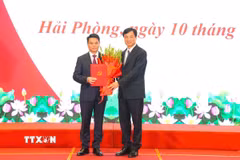 Đồng chí Nguyễn Duy Ngọc, Ủy viên Bộ Chính trị, Bí thư Trung ương Đảng, Trưởng Ban Tổ chức Trung ương tặng hoa chúc mừng đồng chí Lê Ngọc Châu. (Ảnh: Hoàng Ngọc/TTXVN)