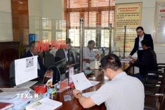 Người dân đến thực hiện các thủ tục hành chính tại bộ phận một cửa của xã được cán bộ, công chức hướng dẫn tận tình. (Ảnh: Thanh Vân/TTXVN)