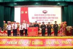 Tỉnh ủy Cà Mau tặng Đại hội bức trướng mang dòng chữ ‘‘Trung thành-Dũng cảm-Đoàn kết-Quyết thắng’’. (Ảnh: Kim Há/TTXVN)
