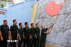 Các cựu chiến binh trở lại Điểm cao 468, tự hào dưới lá cờ Tổ quốc trên chiến trường xưa. (Ảnh: Đức Thọ/TTXVN)