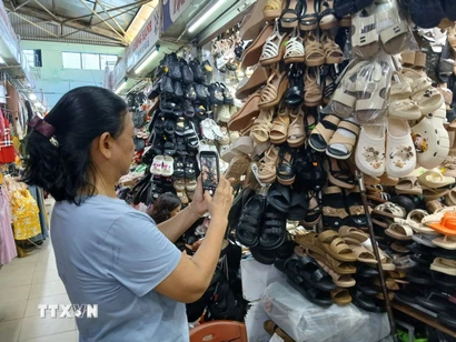 Tiểu thương chợ Đống Đa, thành phố Đà Nẵng ứng dụng zalo để bán hàng trực tuyến. (Ảnh: Mỹ Hà/TTXVN)