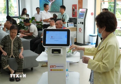 Người dân trải nghiệm các robot phục vụ. (Ảnh: Hữu Duyên/TTXVN)