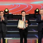 Đại diện nhóm tác giả - nhà báo Võ Mạnh Hùng - nhận giải thưởng. (Ảnh: Hoài Nam/Vietnam+)