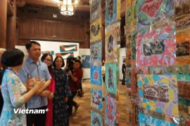 Ông Lê Xuân Kiêu, Giám đốc Trung tâm Hoạt động Văn hóa Khoa học Văn Miếu-Quốc Tử Giám cùng các họa sỹ tham quan triển lãm. (Ảnh: Minh Thu/Vietnam+)