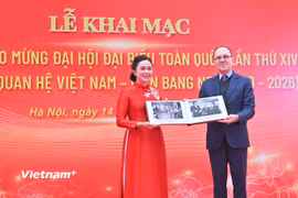 Giám đốc Khu Di tích Chủ tịch Hồ Chí Minh tại Phủ Chủ tịch Lê Thị Phượng tiếp nhận hiện vật từ Đại sứ Liên bang Nga Gennady S. Bezdetko. (Ảnh: PV/Vietnam+)