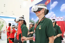 Khách tham quan "xuyên không" trở về thời điểm lịch sử trọng đại của đất nước thông qua công nghệ hiện đại trong triển lãm. (Ảnh: PV/Vietnam+)