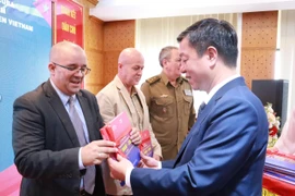 Phó Giáo sư-Tiến sỹ Vũ Trọng Lâm trao tặng sách cho Đại sứ quán Cuba tại Việt Nam và đại diện các ban, bộ, ngành, cơ quan dự buổi lễ ra mắt. (Ảnh: PV/Vietnam+)
