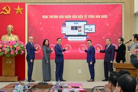 Các đại biểu cùng bấm nút khai trương Báo Nhân Dân điện tử tiếng Hàn Quốc, đánh dấu mốc ấn phẩm điện tử tiếng nước ngoài thứ 6 của Báo Nhân Dân chính thức hòa mạng internet. (Ảnh: PV/Vietnam+)