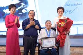 Bà Vũ Việt Trang, Tổng Giám đốc Thông tấn xã Việt Nam (trái) và nhà thơ Trần Đăng Khoa trao giải Hiệp sỹ Dế Mèn cho nhạc sỹ Phạm Tuyên. (Ảnh: PV/Vietnam+)