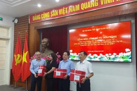 Thứ trưởng Bộ Văn hóa, Thể thao và Du lịch Phan Tâm trao cuốn cẩm nang cho đại diện một số Sở Văn hóa địa phương. (Ảnh: Minh Thu/Vietnam+) 