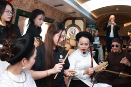 Thí sinh Cuộc thi Tiếng hát Hà Nội năm 2025 tìm hiểu về âm nhạc dân gian truyền thống trong không gian toa tàu "Hà Nội 5 cửa ô." (Ảnh: PV/Vietnam+)